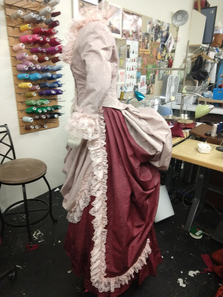 With attached petticoat and back ruffles Victorian cage bustle